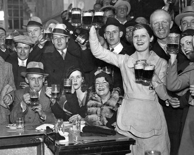 People drinking at a bar in the 1920's.