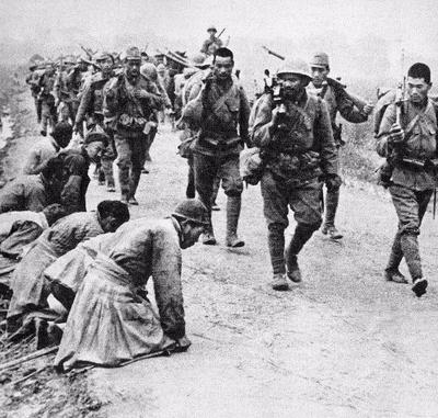 Japanese soldiers march through China. Chinese soldiers are on the left ...